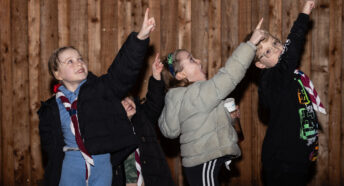 Four children pointing up at the sky